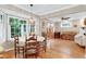 Dining area featuring a bay window, hardwood floors, and white kitchen cabinets at 109 Reton Ct, Cary, NC 27513