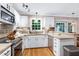 Kitchen features white cabinets, stainless steel appliances, and stone countertops at 109 Reton Ct, Cary, NC 27513