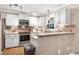 Kitchen features white cabinets, stainless steel appliances, and stone countertops at 109 Reton Ct, Cary, NC 27513