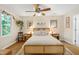 Bright main bedroom features a ceiling fan, a rattan bed frame and bedside tables, and decor at 109 Reton Ct, Cary, NC 27513