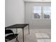 Bright room with two windows, neutral carpet, and a dark folding table and chair at 110 Cambria Ln, Morrisville, NC 27560