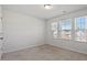 Well-lit bedroom with neutral carpeting and multiple windows at 110 Cambria Ln, Morrisville, NC 27560