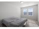 Bedroom with carpet and two windows, furnished with a bed frame and a gray comforter at 110 Cambria Ln, Morrisville, NC 27560