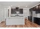 Modern kitchen with dark cabinetry, stainless steel appliances, and a large island at 110 Cambria Ln, Morrisville, NC 27560