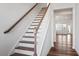Elegant staircase with wooden handrail and white spindles leading to the upper level at 110 Cambria Ln, Morrisville, NC 27560