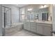 Luxurious bathroom featuring dual vanities, soaking tub, and a glass-enclosed shower at 1112 Leatherstone Ln, Fuquay Varina, NC 27526