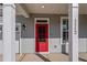 Close up of a stylish red front door framed by white columns and siding at 1112 Leatherstone Ln, Fuquay Varina, NC 27526