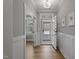 Bright and airy hallway with hardwood floors and views of the front door and a shuttered window at 1112 Leatherstone Ln, Fuquay Varina, NC 27526