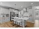 Modern, all-white kitchen with stainless steel appliances, bar stool seating, and a large island at 1112 Leatherstone Ln, Fuquay Varina, NC 27526