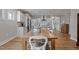 A charming, bright kitchen boasts white cabinets, modern appliances and a large wooden table at 1112 Leatherstone Ln, Fuquay Varina, NC 27526
