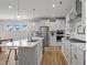 Modern, all-white kitchen with stainless steel appliances and a large island with pendant lighting at 1112 Leatherstone Ln, Fuquay Varina, NC 27526