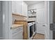 Well-organized laundry room with washer, dryer, butcher block counter, and storage cabinets at 1112 Leatherstone Ln, Fuquay Varina, NC 27526