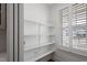 Bright pantry featuring white shelving, window, and hardwood floors at 1112 Leatherstone Ln, Fuquay Varina, NC 27526