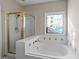 Bathroom featuring a soaking tub, a separate glass enclosed shower, and a stained glass window at 118 N Drawbridge Ln, Cary, NC 27513