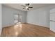 Bright bedroom with hardwood floors, sliding glass doors to a porch, ceiling fan, and white walls at 118 N Drawbridge Ln, Cary, NC 27513