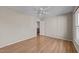 Neutral bedroom features hardwood flooring, white ceiling fan, and a closet off of the hall at 118 N Drawbridge Ln, Cary, NC 27513