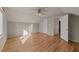 Neutral bedroom features hardwood floors, a ceiling fan, closet, and white doors at 118 N Drawbridge Ln, Cary, NC 27513