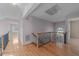 Bright hallway with hardwood floors leads to bedrooms and features an ornate wrought iron railing at 118 N Drawbridge Ln, Cary, NC 27513