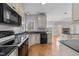 Bright kitchen with stainless steel appliances, wood floors, an island and a view of the living space at 118 N Drawbridge Ln, Cary, NC 27513