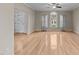 Open living room featuring hardwood floors, neutral walls, a ceiling fan, large windows and a stained glass door at 118 N Drawbridge Ln, Cary, NC 27513