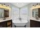 Well-lit bathroom features a clawfoot tub, glass shower, and dual vanities at 126 Claire Dr, Clayton, NC 27520