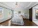 Bright main bedroom with dark wood floors, a ceiling fan, and a barn door to the ensuite bath at 126 Claire Dr, Clayton, NC 27520