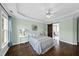 Comfortable bedroom with a tray ceiling, ceiling fan, beautiful light-green walls and hardwood floors and large windows at 126 Claire Dr, Clayton, NC 27520