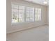 Bright bedroom features neutral carpet, light walls, and three large windows at 1324 Vanagrif Ct, Wake Forest, NC 27587