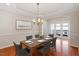 Elegant dining room boasts hardwood floors, crown molding, and a modern chandelier for sophisticated meals at 1324 Vanagrif Ct, Wake Forest, NC 27587