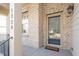 Welcoming front porch of this house with brick facade, and a black front door at 1324 Vanagrif Ct, Wake Forest, NC 27587