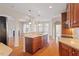 Open-concept kitchen with eat-in bar, stainless appliances, and hardwood floors, seamlessly flowing into the living area at 1324 Vanagrif Ct, Wake Forest, NC 27587