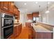 Modern kitchen with stainless steel appliances, granite countertops, and warm wood cabinetry for culinary enthusiasts at 1324 Vanagrif Ct, Wake Forest, NC 27587