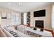 Bright living room features hardwood floors, fireplace, custom built-ins, and a large TV for entertainment at 1324 Vanagrif Ct, Wake Forest, NC 27587