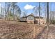 View of backyard and deck, surrounded by trees, with brick under-cladding at 145 Traceway N, Sanford, NC 27332