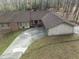 An exterior elevation of a brick and siding home with a long driveway leading to a detached garage at 145 Traceway N, Sanford, NC 27332