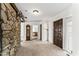 Open-concept living area with a stone wall, wood-look beams, and a view into the dining room at 145 Traceway N, Sanford, NC 27332