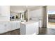 Modern kitchen featuring white cabinets, island, stainless steel appliances, and open view to the living area at 150 Ethel Ln, Angier, NC 27501