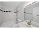 Bright bathroom featuring a shower over tub with blue tiled accents, a white sink, and a large, decorative mirror at 2004 Beecham Cir, Raleigh, NC 27607