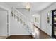 Bright foyer with a staircase featuring carpeted treads and hardwood flooring at 2004 Beecham Cir, Raleigh, NC 27607