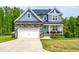 Charming two-story home showcasing a stone facade, attached garage, and inviting front porch with a vibrant turquoise door at 201 Northview Dr, Middlesex, NC 27557