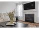 Cozy living room showcases a fireplace, flat-screen TV, flower decor, and white leather couch for relaxation at 201 Northview Dr, Middlesex, NC 27557