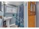 Bathroom features a pedestal sink, modern fixtures, and a shower with patterned curtain at 217 Stephen Taylor Rd, Wake Forest, NC 27587
