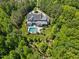 Stunning aerial view of an estate home with a large pool nestled among lush trees and professional landscaping at 219 Colvard Park Dr, Durham, NC 27713
