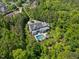 Breathtaking aerial shot showcases the estate's pool and meticulous landscaping embraced by a vibrant green forest backdrop at 219 Colvard Park Dr, Durham, NC 27713