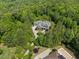 Stunning aerial view of an estate home surrounded by a canopy of trees and beautiful landscaping at 219 Colvard Park Dr, Durham, NC 27713