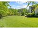 Expansive backyard featuring lush lawn, manicured landscaping and mature trees offering shade and privacy at 219 Colvard Park Dr, Durham, NC 27713