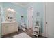 Bathroom features a unique seashell mirror, complemented by the calming blue walls and wood-look tile flooring at 219 Colvard Park Dr, Durham, NC 27713