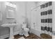 Clean and modern bathroom with a pedestal sink, tile floor, and tub with shower at 219 Colvard Park Dr, Durham, NC 27713