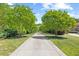 Long paved driveway lined with trees leads up to the grand house on a sprawling, well-manicured lawn at 219 Colvard Park Dr, Durham, NC 27713
