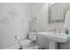 Clean powder room with a pedestal sink, modern fixtures, and decorative wall art at 219 Colvard Park Dr, Durham, NC 27713